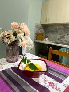 a table with a bowl of lemons and a vase of flowers at Kroi'Pistolve in Krujë