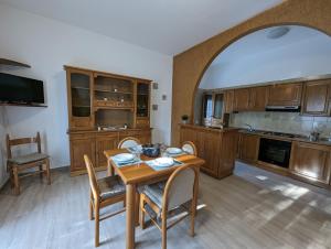 una cocina con mesa, sillas y un arco en Holiday House 2, en Villamagna