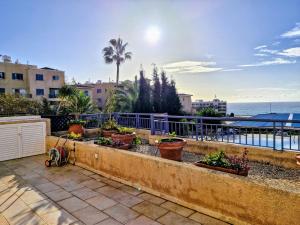 a row of potted plants on a wall near the ocean at Givon Palace in Paphos City