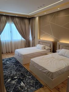 um quarto com 2 camas e uma grande janela em شقة ألترا لوكس بالمهندسين no Cairo