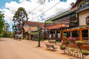 uma rua com bancos e edifícios numa rua da cidade em Apartamento Le Quatre Centro Monte Verde em Monte Verde