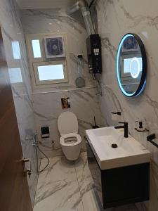 W łazience znajduje się toaleta, umywalka i lustro. w obiekcie شقة ألترا لوكس بالمهندسين w Kairze