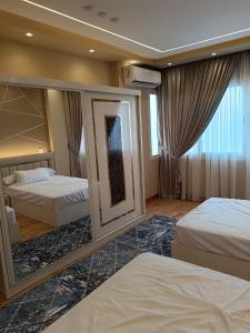 una camera d'albergo con due letti e uno specchio di شقة ألترا لوكس بالمهندسين a Il Cairo