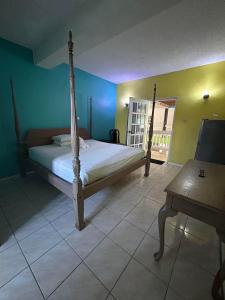 a bedroom with a bed in a room with a table at Bay Heights Escape in Gros Islet