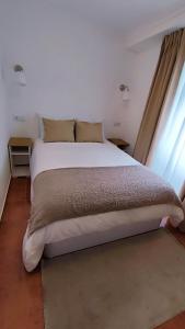 a large bed in a room with a window at The River House in Peso da Régua