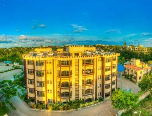 uma vista superior de um edifício amarelo em Roma Stays - Elegant Apartment at Sunset Paradise with Swimming Pool & Restaurant em Mombasa