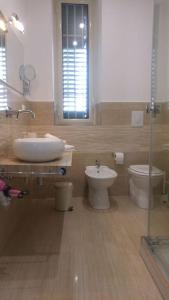 ein Badezimmer mit einem Waschbecken, einem WC und einem Spiegel in der Unterkunft B&T Holiday House in Palermo