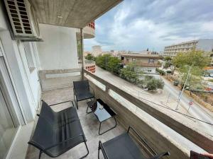 a balcony with chairs and a view of a street at Luxurious 3rd floor apartment with elevator in Alexandroupoli