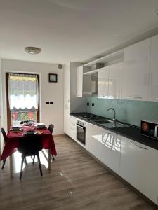 a kitchen with a table and a kitchen with white cabinets at Casa Vacanza La Croseta in Trento