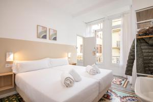 a white bedroom with a large bed and a sink at Pensión Alicante by Moontels in Valencia