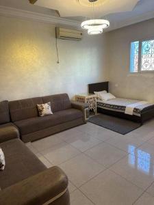 salon z kanapą i łóżkiem w obiekcie Villa spacieuse 200 m à la plage w mieście Dżardżis
