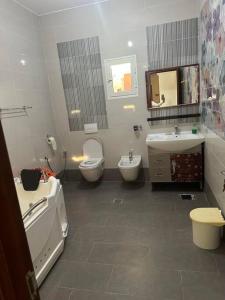 łazienka z 2 toaletami i umywalką w obiekcie Villa spacieuse 200 m à la plage w mieście Dżardżis