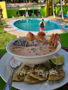 a plate of food with shrimp and nachos next to a pool at hostal y Restaurante Entre Olas in La Libertad