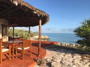 a patio with a table and chairs and the ocean at Manga Lodge in Andavadoaka