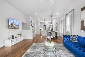 a living room with a blue couch and a table at Lux Living - East Downtown Rooftop with King Suite & Private Chef in Houston