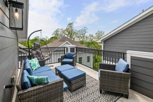 a patio with wicker chairs and tables on a balcony at Lux Living - East Downtown Rooftop with King Suite & Private Chef in Houston