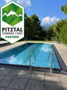 ein Pool mit einem Schild, das einen privaten Sommerkartenpartner liest in der Unterkunft Appartements Dobler - s'Zischgn in Arzl im Pitztal