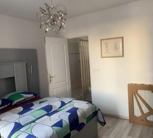 a bedroom with a bed and a chandelier at appartement d'artiste in Fontenay-sous-Bois