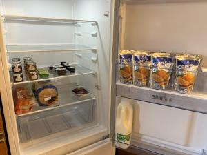 an open refrigerator filled with lots of food and drinks at Delightful self-contained Annexe close to airport in Norwich