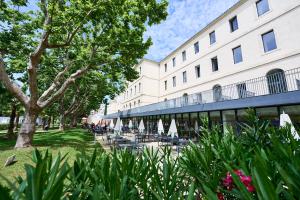 a building with tables and chairs in front of it at Villages Clubs du Soleil - MARSEILLE in Marseille