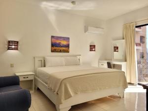 a bedroom with a large bed and a chair at Aparta Hotel Drake Bolivar in Santo Domingo