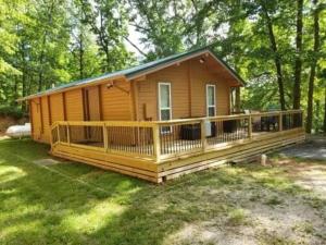 una pequeña casa con una gran terraza en el patio en Beaver Lake Arkansas Luxury Cabin, en Rogers