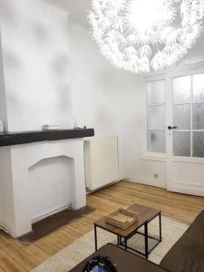 a living room with a fireplace and a chandelier at appartement style haussmannien in Brussels