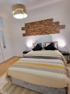 een slaapkamer met een groot bed met een bakstenen muur bij appartement style haussmannien in Brussel