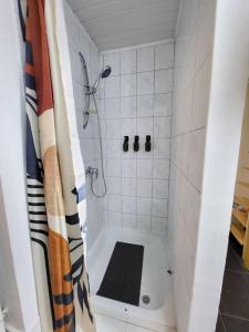 a bathroom with a shower with a black and white shower curtain at appartement style haussmannien in Brussels