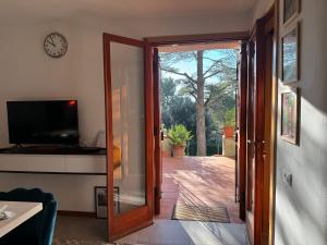 an open door to a patio with a clock on the wall at VILLA TARA in Quercianella