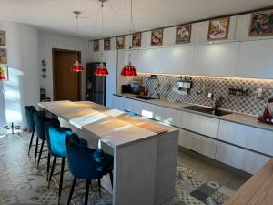 une cuisine avec une grande table et des chaises bleues dans l'établissement VILLA TARA, à Quercianella