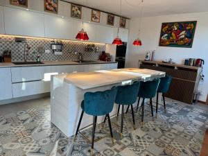 a kitchen with a table and some blue chairs at VILLA TARA in Quercianella