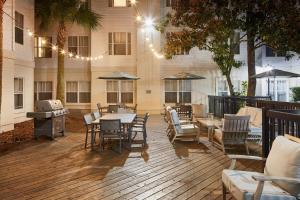 um pátio com uma mesa, cadeiras e comodidades para churrascos em Residence Inn By Marriott Charleston Mt. Pleasant em Charleston