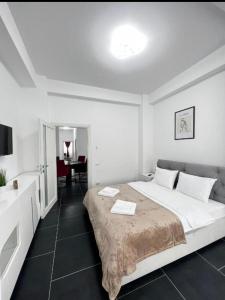 ein weißes Schlafzimmer mit einem großen Bett und einem Schreibtisch in der Unterkunft Dream house in Knightswood