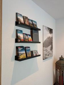 Una pared con estanterías con libros. en Apart Bergglück, en Sankt Leonhard im Pitztal