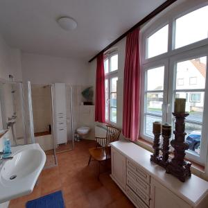 un bagno con lavandino, WC e finestra di Privatunterkunft im Erdgeschoss a Nordenham