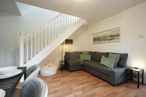 a living room with a couch and a staircase at Tapton View - Modern Stay Near Chesterfield Town Center, Train Station & the Peak District in Brimington