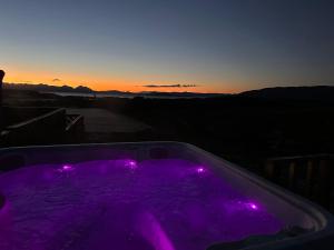 a purple hot tub with purple lights at sunset at Duirinish Pods with Private Hot Tubs and Duirinish Bothy with No Hot Tub in Plockton