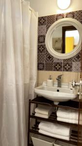 ein Badezimmer mit einem Waschbecken, einem Spiegel und Handtüchern in der Unterkunft ANGELOS STUDIOS 1-2 Ground Floor in Faliraki