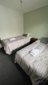 two beds in a hotel room with at Anoka House in Punta Arenas