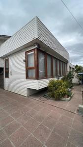 a small white building with windows on a patio at Anoka House in Punta Arenas
