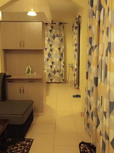 a room with a kitchen and a living room at Roma Stays - Spacious 1BR Sunset Paradise Apartment with Swimming Pool in Shanzu in Mombasa