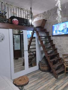 Zimmer mit einer Treppe und einem TV an der Wand in der Unterkunft Dimora Forgione B&B - Pietrelcina in Pietrelcina