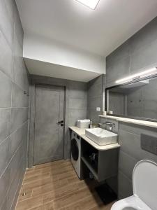 a bathroom with a sink and a washing machine at B.L Apartaments in Bucharest +19 photos