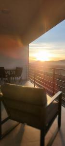 a view of the sunset from a balcony with a couch at Sunset Hills Transylvania in Odorheiu Secuiesc