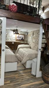 1 Schlafzimmer mit 2 Betten und einer Steinmauer in der Unterkunft Dimora Forgione B&B - Pietrelcina in Pietrelcina