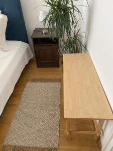 una mesa de madera en una habitación con cama y escritorio en Nosztalgia Apartman en Veszprém