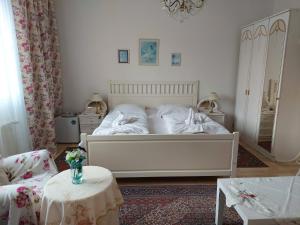 een slaapkamer met een wit bed en 2 tafels bij Hotel Garni in Ostrava