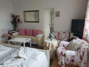 een woonkamer met een bank en stoelen en een tv bij Hotel Garni in Ostrava