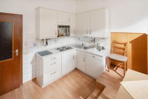 eine Küche mit weißen Schränken und Holzböden in der Unterkunft Haus Tiemann Wohnung 2 in Norderney
